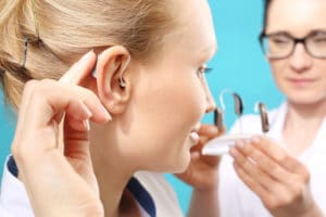 young woman trying on hearing aids