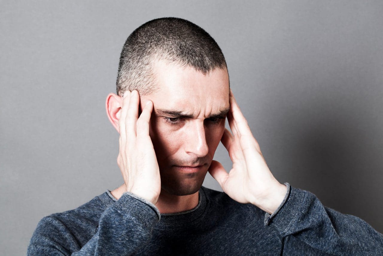 A person holding their head in distress from tinnitus
