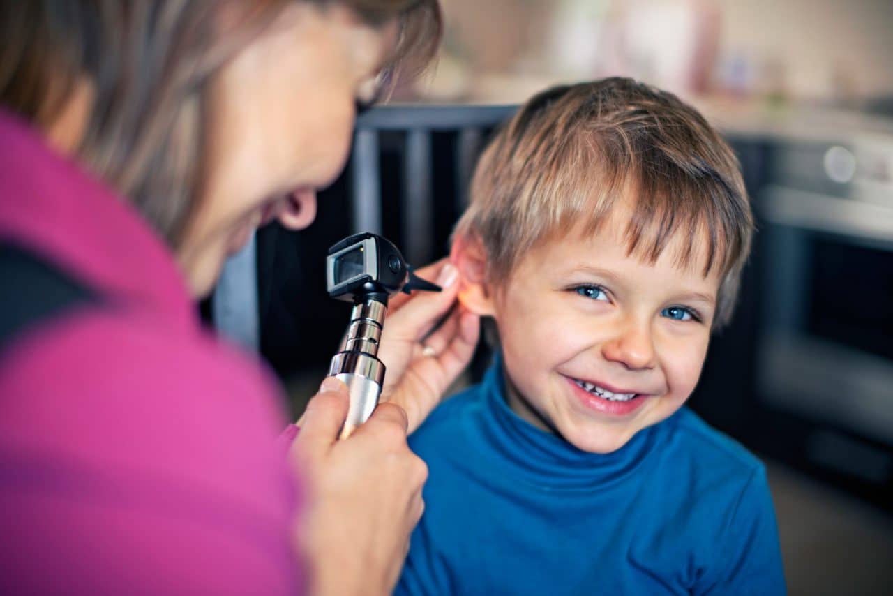 Young boy getting his ears checked by a doctor