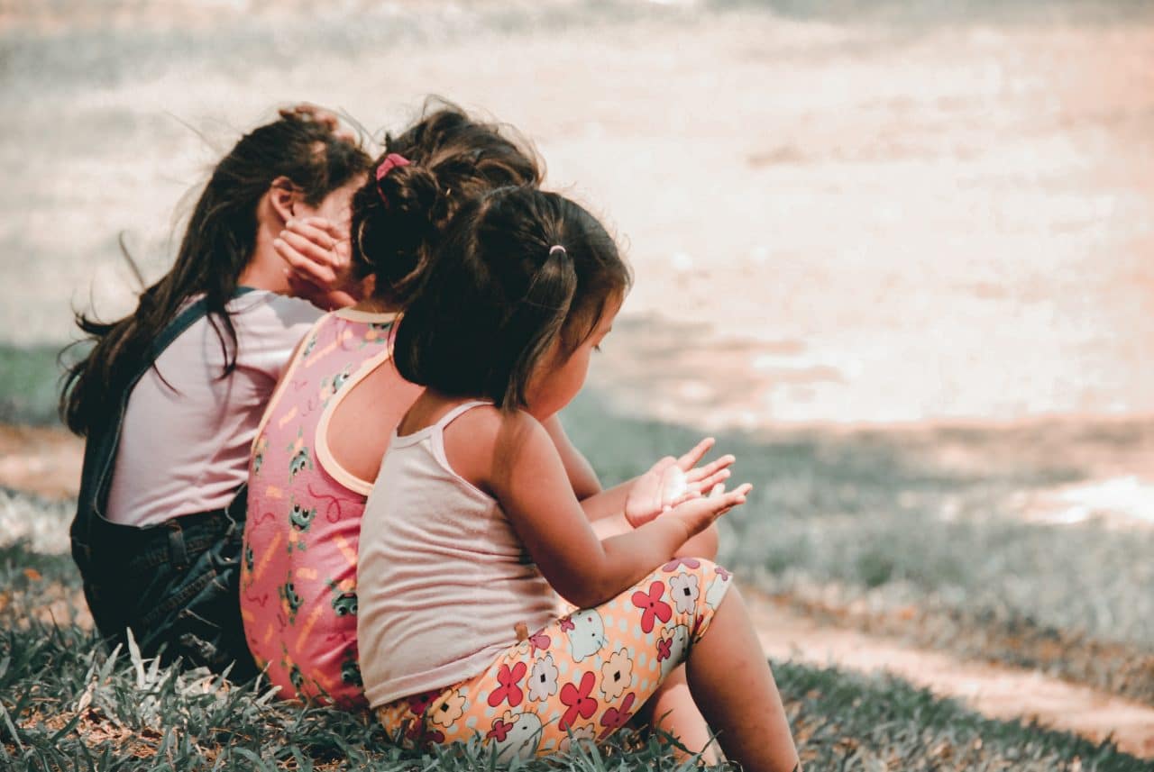 Children sitting together outside.