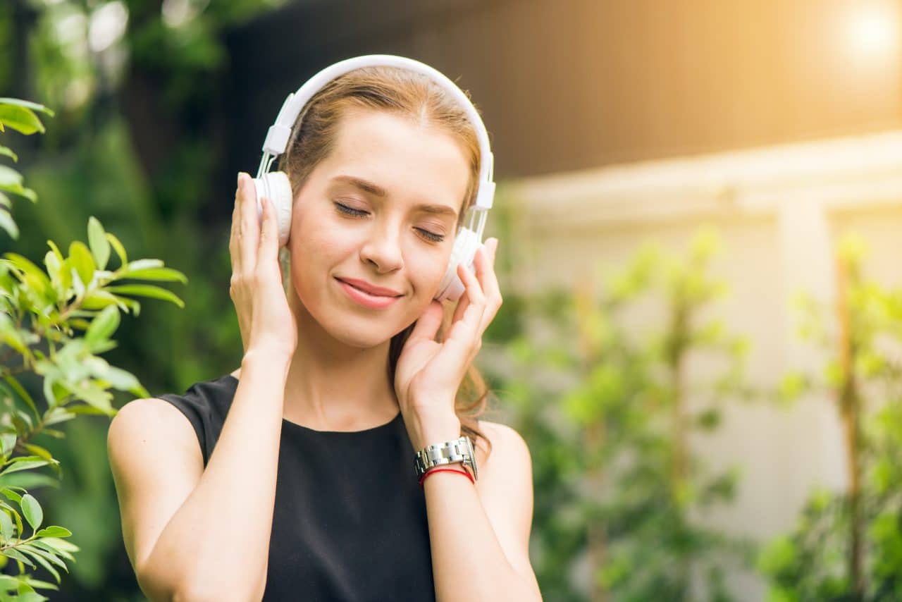 Woman happily listening to music on her headphones.