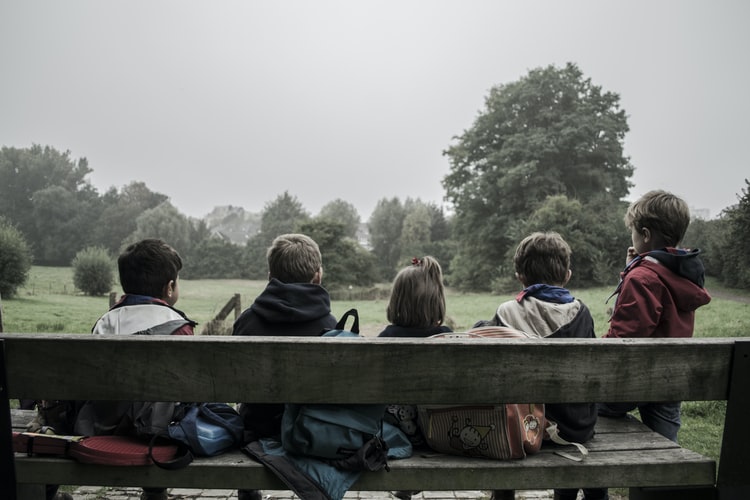 Children sitting together outside.