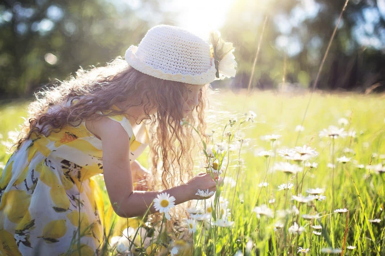 Little girl smelling flowers in the springtime.