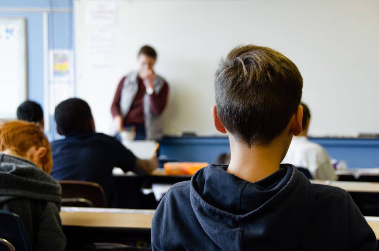 Students sitting and paying attention in a teacher's classroom.