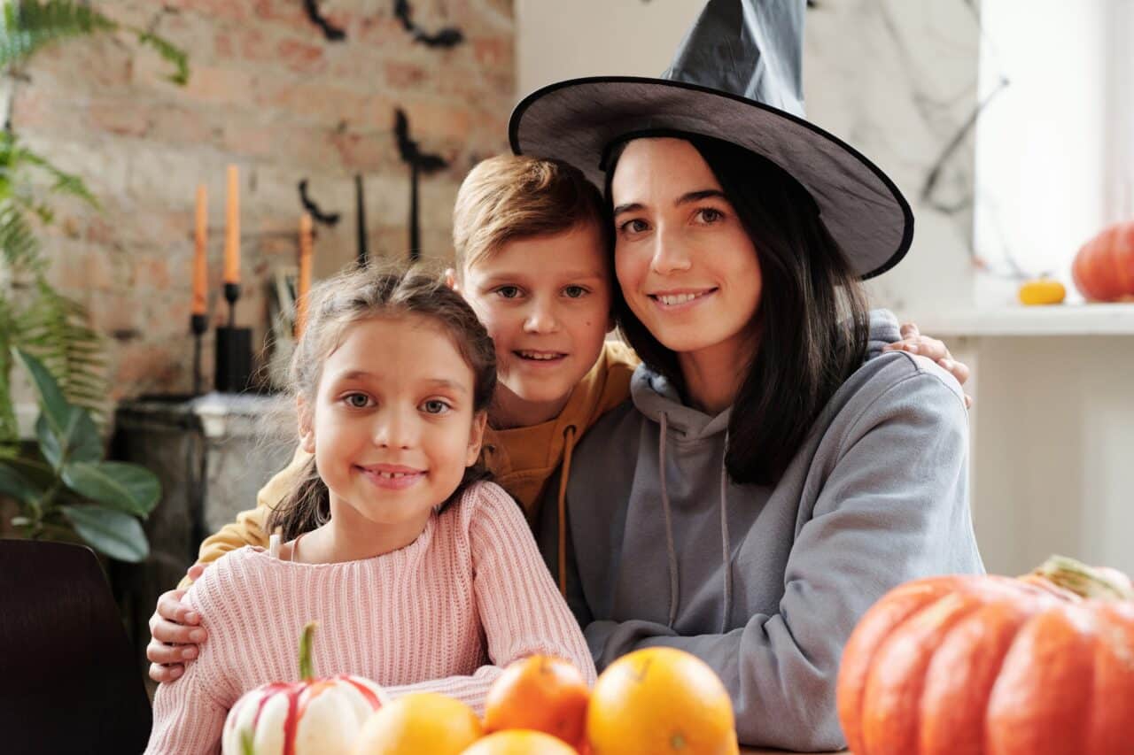 Mom and children decorating pumpkins for Halloween.