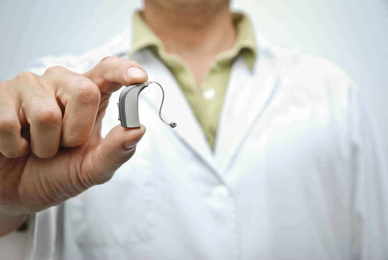 Man holds small hearing aid