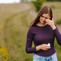 Woman with allergies rubs eyes