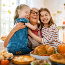 Happy grandma hugging her granddaughters on Thanksgiving