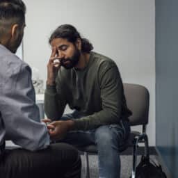 Stressed man talking to a counselor