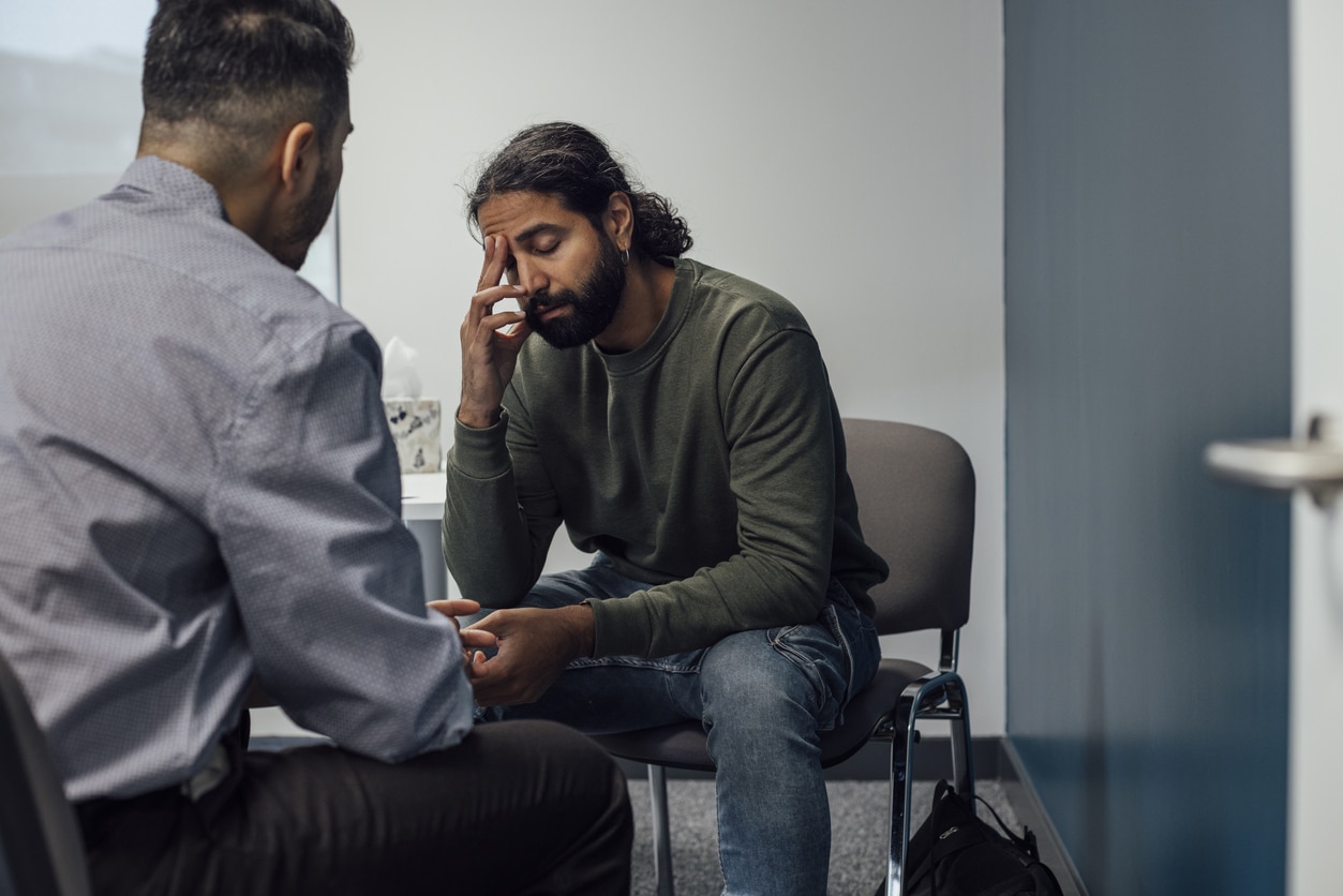 Stressed man talking to a counselor.