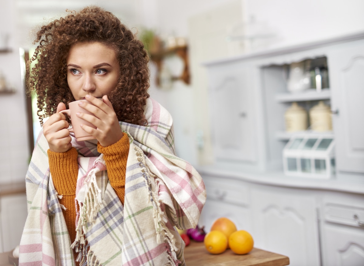 Woman with a cold drinking a hot cup of tea