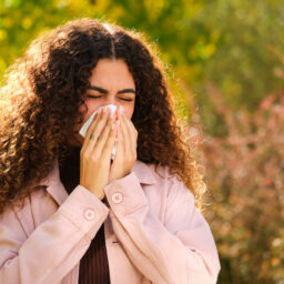 Woman sneezes in park